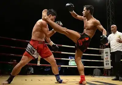 Kickboxer using a high kick during a ring exchange