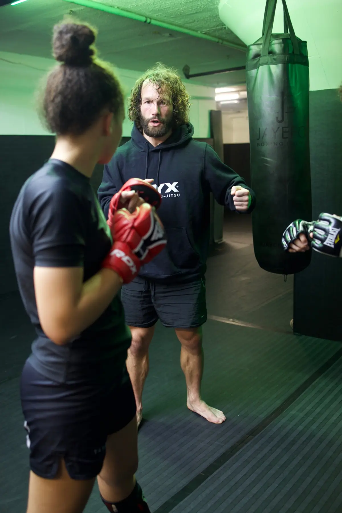 A coach guiding a student through striking practice at Onyx