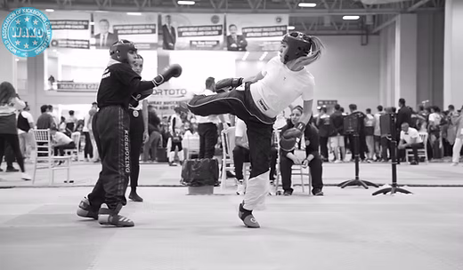 Two kickboxers exchanging a head kick in point-fighting competition