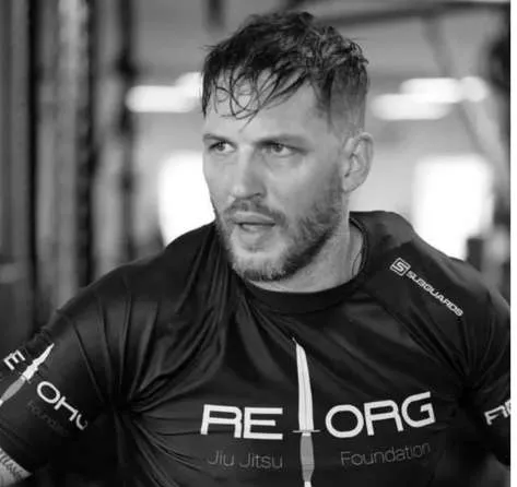 Tom Hardy wearing a REORG Jiu Jitsu Foundation training shirt