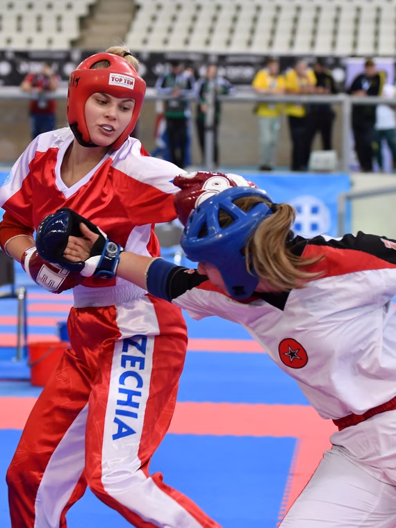 Two female kickboxers exchanging punches in competition